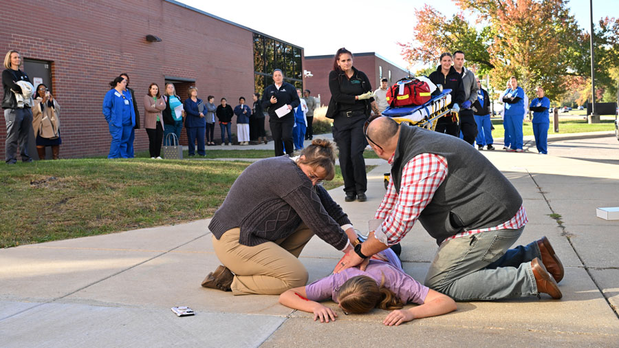 Several students and teachers outside participating in a health careers training simulation
