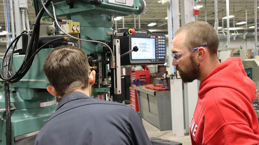 Two students working on a milling machine