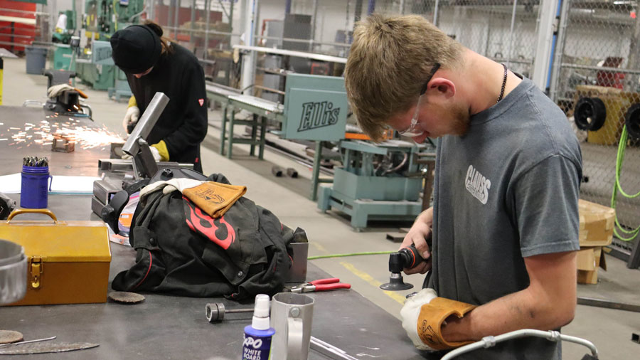Two students using pneumatic grinders