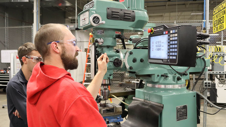 Two students working on a milling machine