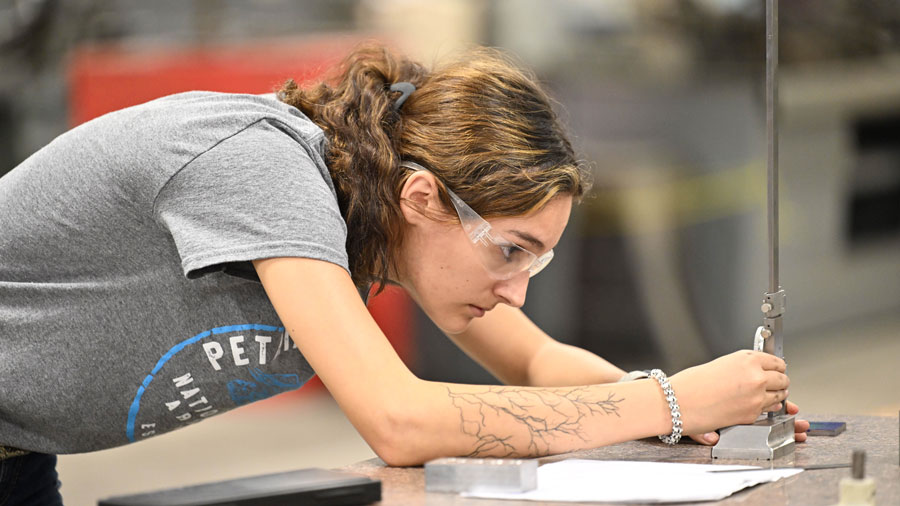 Student measuring a piece of metal