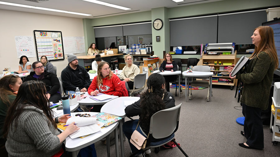Instructor giving a presentation to students at the front of a classroom