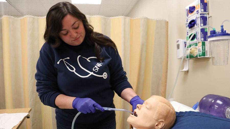 Student training in a simulated hospital room using a medical manikin