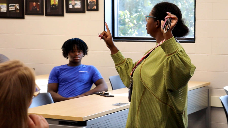 Instructor at the front of a classroom holding handcuffs and a handcuff key