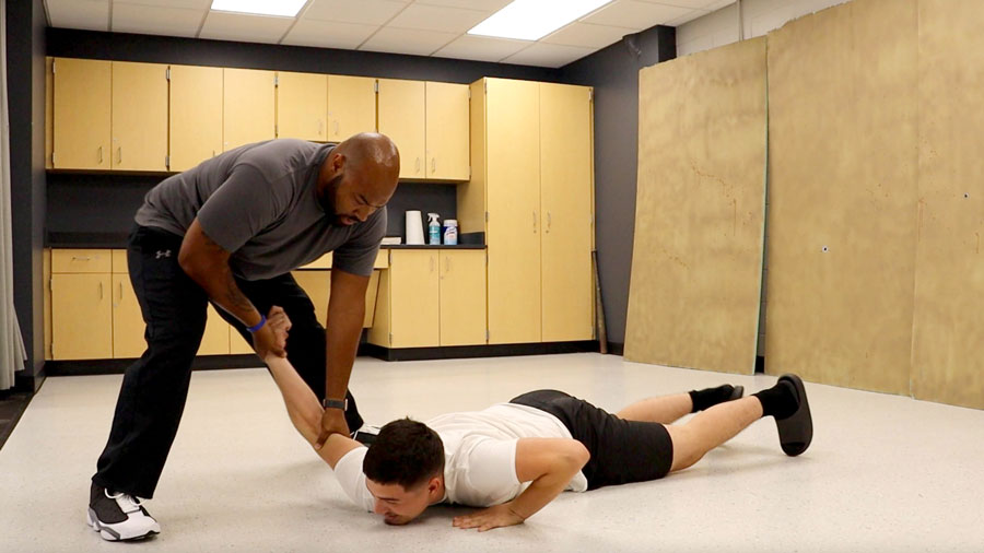 Instructor and student demonstrating how to pin someone on the floor