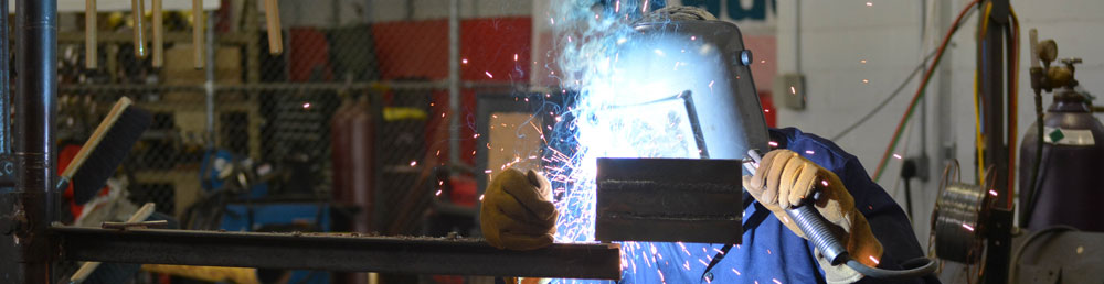 Student using a SMAW welder on a vertical peice of metal