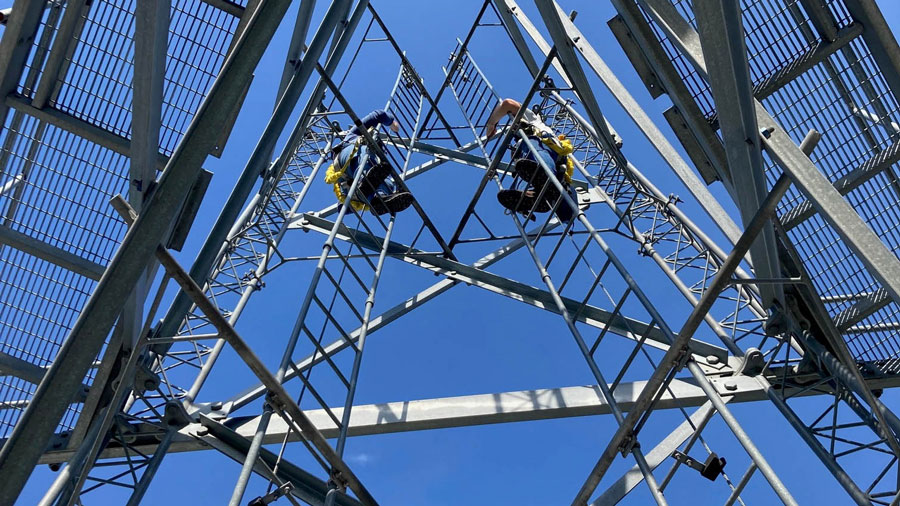 Two students in the air on metal ladders and scafolding