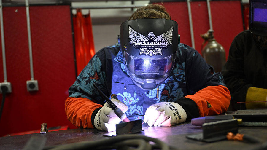 Instructor demonstrating the use of a TIG welder