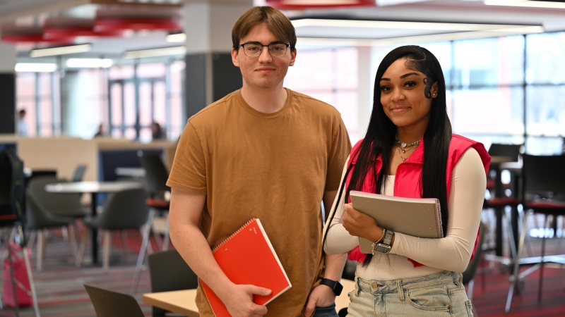 Students carrying their studying journals in the college center.