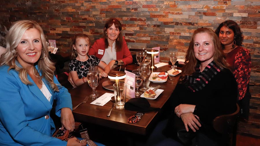 Table of four plus a kid enjoying a KCC Foundation event.