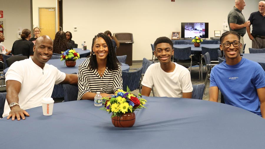 Family of four smiling at the Lady Cavs reunion.