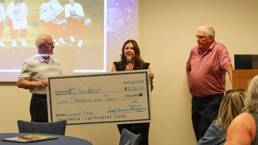 Kari Nugent holding a large check for the Cavalier Fund at the Lady Cavs reunion.