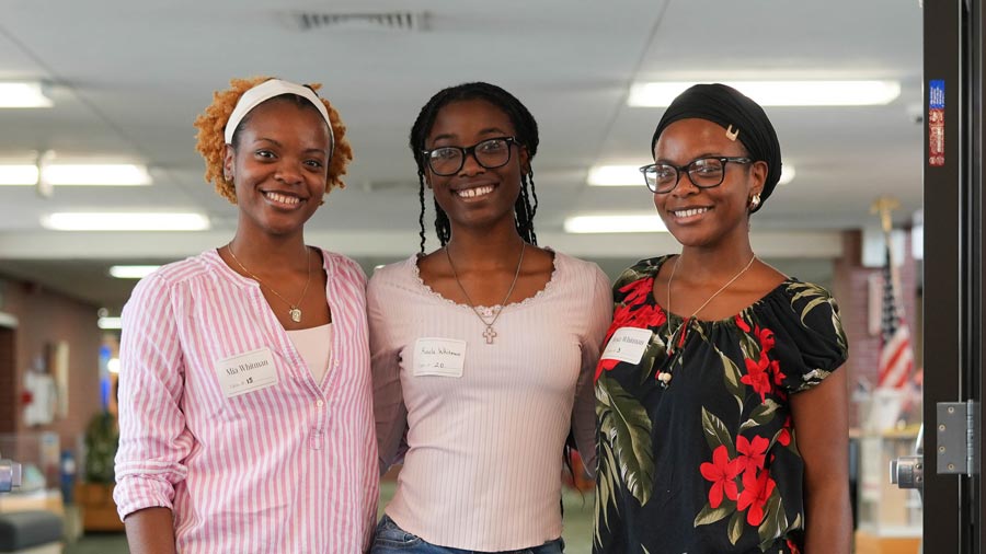 Three smiling students at the scholarship luncheon.