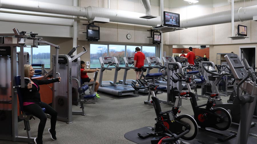 Four individuals using various exercise equipment